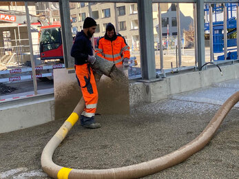 Der Splittunterbau im Gewächshaus wird mit einem Blasgerät für die anschliessende Verlegung der Pflastersteine eingebracht.